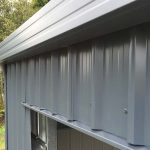 Close-up of Colorsteel cladding and flashing detail on a steel shed showing clean lines and weatherproof finish
