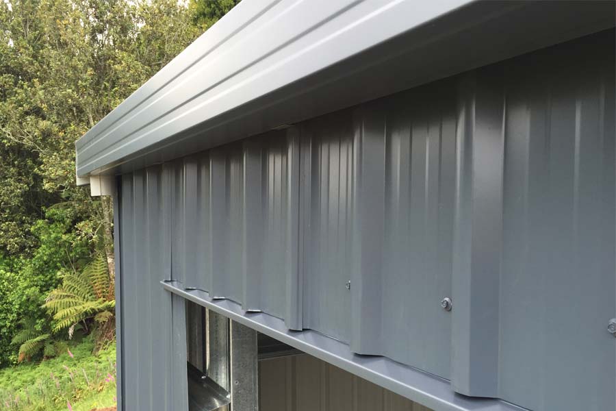 Close-up of Colorsteel cladding and flashing detail on a steel shed showing clean lines and weatherproof finish