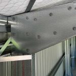 Steel shed knee connection with heavy bolted plate joining column and rafter