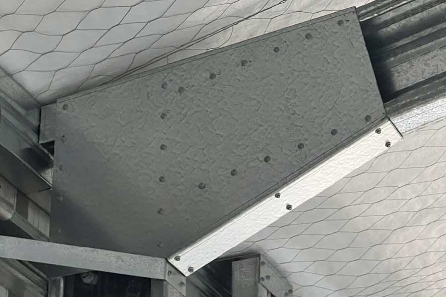 Steel shed knee back plate fixed with tek screws showing enclosed connection without angled knee brace